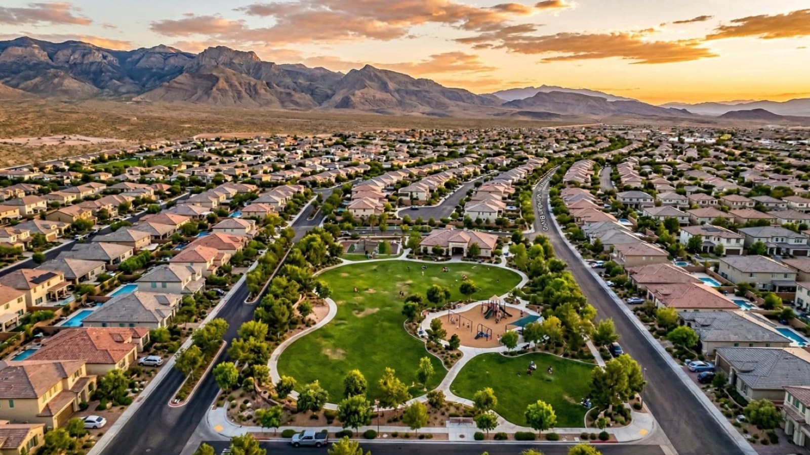Las Vegas master-planned neighborhood with Red Rock Canyon backdrop and winding streets at dusk